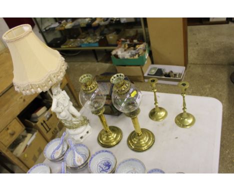 A pair of brass and glass candle lanterns; a coloured glass lantern; a figural table lamp; and a pair of brass candlesticks 