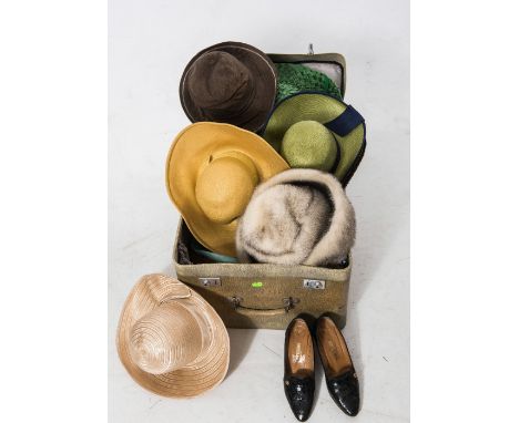 A vintage suitcase a large quantity of hats together with a pair of faux crocodile shoes