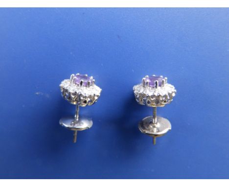 A pair of amethyst &amp; diamond cluster earrings in '18k' white metal.