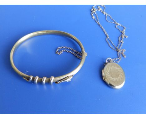 A yellow metal bangle - repaired and a locket on chain.