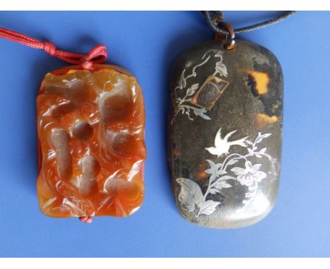 A Chinese peach jade coloured rectangular pendant relief carved to one side with flowerheads and branches, shallow carved to 