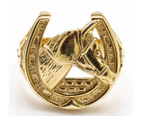 A 9ct gold / 375 marked Horseshoe ring. The ring with horse shoe and horse head centre with tapering shoulders having helmet 