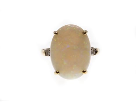 A hallmarked 9ct gold opal and diamond ring. The ring set with an Australian opal cabochon approx 16mm x 12mm, flanked by two