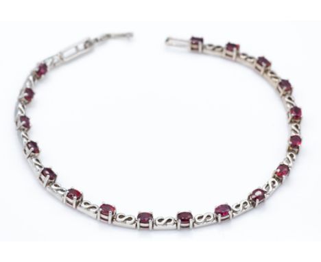 A hallmarked 9ct gold Malawi ruby bracelet. The bracelet set with 18 oval cut Malawi ruby (approx 4.3ct) with S link spacers 