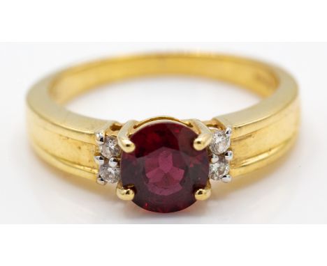 A hallmarked 18ct gold and AAA Tanzanian ruby and diamond ring. The ring set with a AAA&nbsp; oval cut Tanzanian ruby flanked