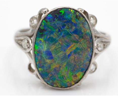 An Art Nouveau platinum black opal and diamond ring. The ring bezel set with a black opal&nbsp; 14.3mm x 10.2mm x 3.4mm havin