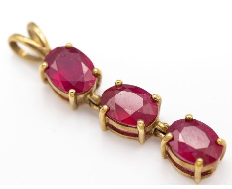 A hallmarked 9ct gold and ruby necklace pendant the pendant being strung with 3 oval cut rubies (approx 6mm x 8mm) having art