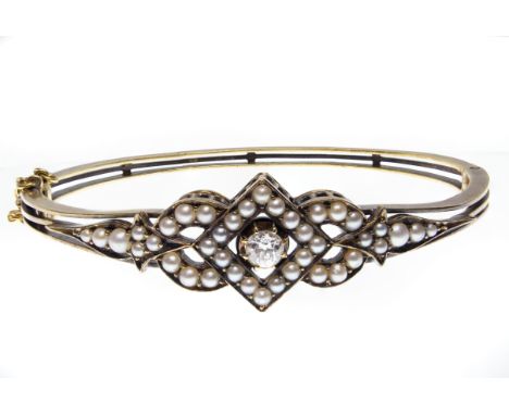 A 19th century Victorian 15ct gold, diamond and half pearl bangle bracelet. The bangle set with a central old cut diamond fra