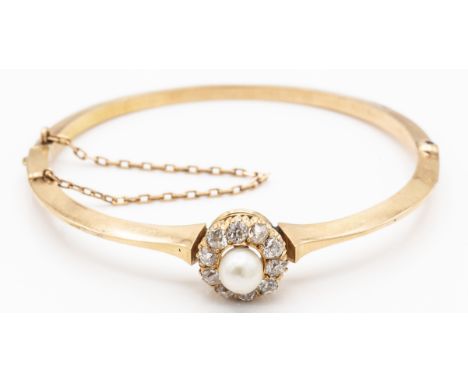 A French 18ct gold diamond and pearl hinged bangle. The bangle set with a central pearl&nbsp; (pink overtone) framed by 10 ol