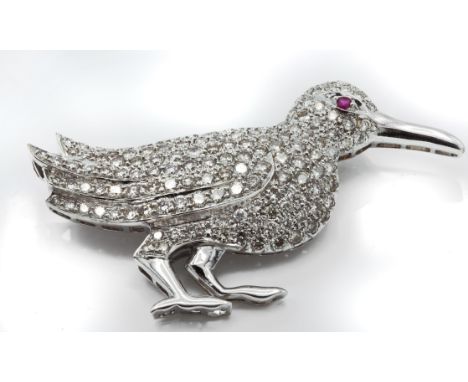A French 18ct white gold ruby and diamond bird brooch. The brooch in the form of a bird having a pavé set diamond body and a 