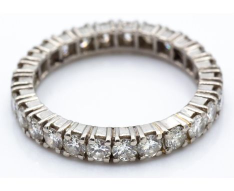 A French platinum and diamond eternity ring. The ring set with 26 round brilliant cut diamonds in a claw setting. French assa