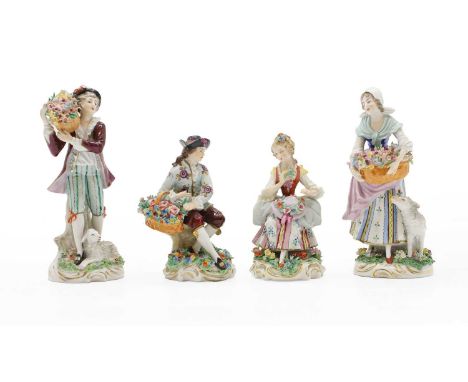 A pair of Dresden porcelain shepherd and shepherdess figures, c.1920, traditional period costume, each carrying baskets of fl