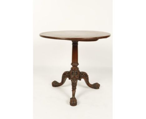 A GEORGE II MAHOGANY TRIPOD TABLE, the circular tip-top on a tapering column and three elaborately carved cabriole legs with 