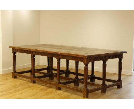 A LARGE ITALIAN WALNUT CENTRE TABLE, the rectangular top with two central planks within a bordered surround, on a fluted frie