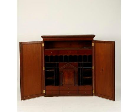 A GEORGE III CABINET with a dental moulded cornice above twin panelled doors enclosing a well fitted interior with central cu