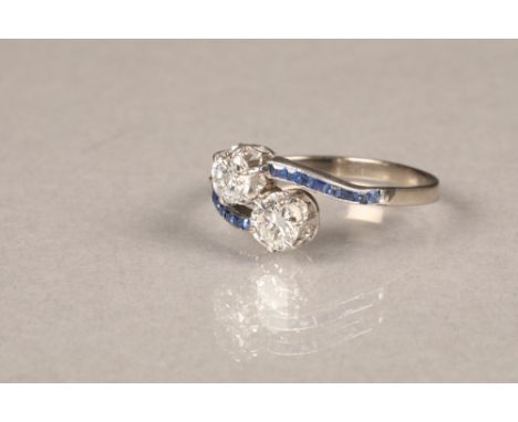 Two stone diamond cross over ring, set with two 0.5 carat brilliant cut diamonds, white metal shank set with sapphire shoulde