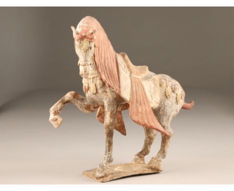 Chinese earthen ware model of a tang horse, on a rectangular base, 37cm high, 34cm long.