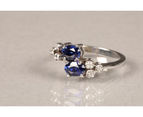 Tanzanite and diamond ring, set in a white metal shank. Two central oval cut tanzanites flanked by three small brilliant cut 