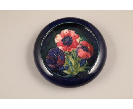 Moorcroft pottery trinket dish/shallow bowl decorated in anemone design on blue ground, incised factory mark, 14cm diameter.C