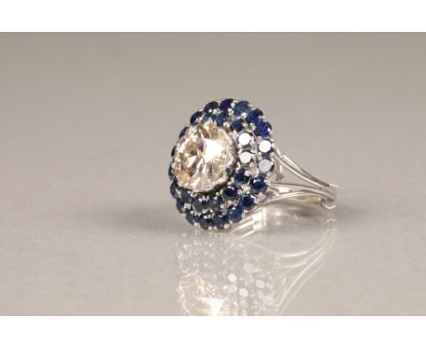 A diamond and sapphire three tiered circular cluster ring, centrally set with brilliant cut diamond surrounded by two tiers o