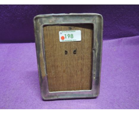 A silver photograph frame of plain rectangular form have wooden easel back, no glass, Birmingham 1917, M Bros
