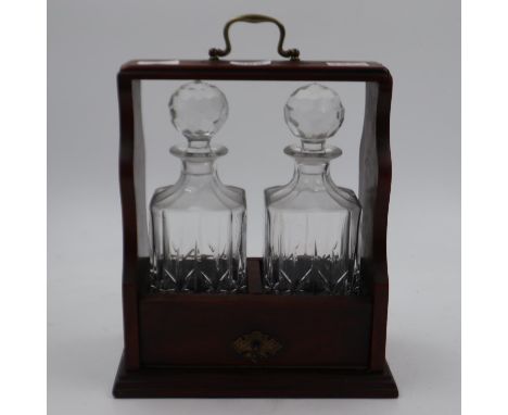 Oak and brass tantalus, containing two crystal decanters, key present. Not available for in-house P&amp;P 