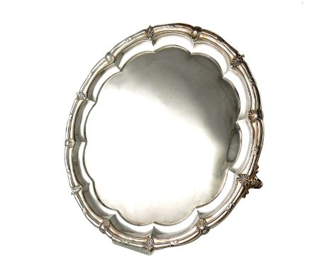 A late-Victorian silver salver, by Hancocks and Co, London 1899, circular form, shell and scroll border, on three shell brack