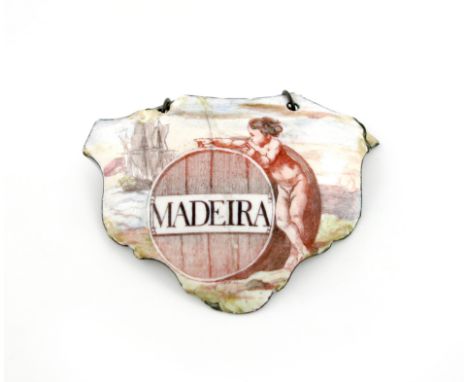 A rare mid 18th century Battersea enamel wine label, circa 1755, escutcheon form, with a cupid resting on a barrel, looking a