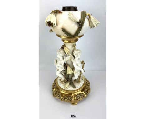 Gilt and porcelain lamp base with 3 cherubs by Moore Brothers, England. 19" high. Some damages and repairs 