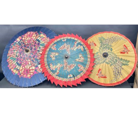 A Chinese paper parasol, decorated with stylised flowers, in tones of pink, red, green and blue, 94cm diameter, c.1930; other