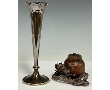 A Japanese paktong inkwell, cast as a dragon grasping a ginger jar, 6cm high; a silver spill vase, 18.5cm high, Chester 1899,