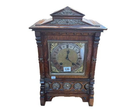 A Continental oak and gilt framed bracket clock with lion head side decoration, 45cm high.