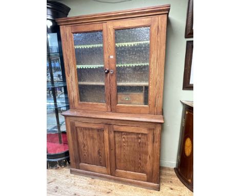 Victorian pitch pine kitchen dresser having two glazed panel doors above two cupboard doors, 207cm by 129cm by 47cm.