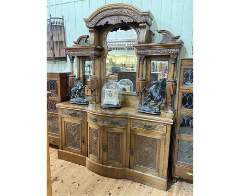 Late Victorian carved oak mirror back sideboard, the canopied mirror back above a bow front centre base of three drawers and 