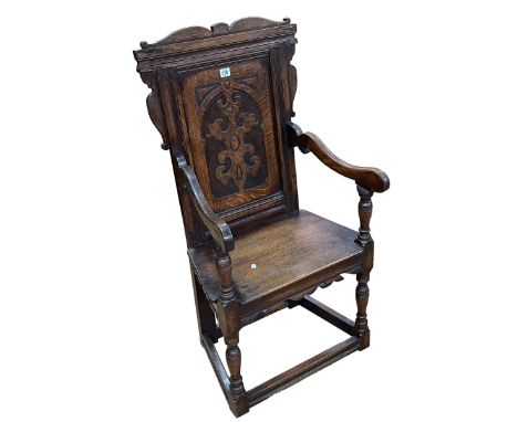 Carved oak panel back elbow chair.