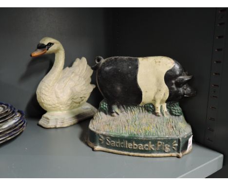 Two vintage cast door stops one as swan and another saddleback pig 