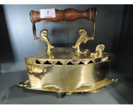 A vintage brass cast stove iron and stand