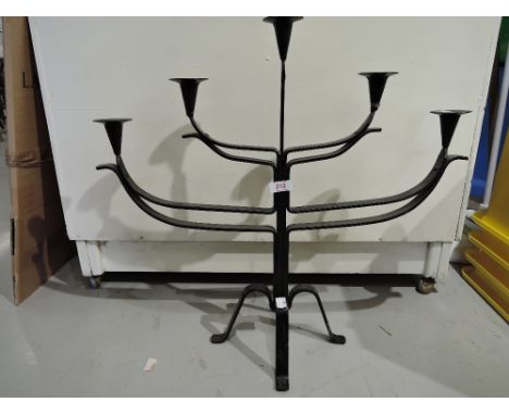 A vintage wrought iron candle stick stand in a menorah style