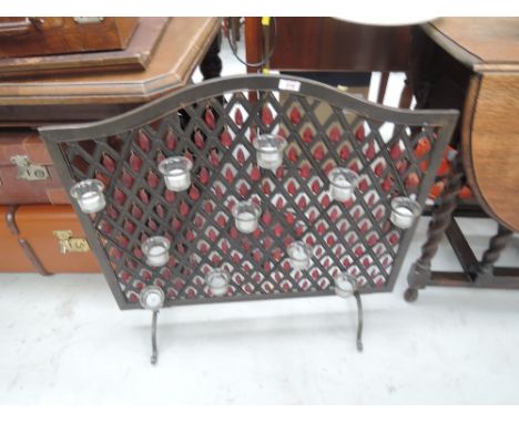 A decorative firescreen having tea light and red glass lustre decoration