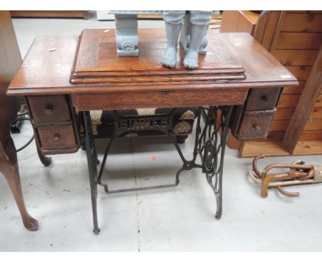A vintage electric Singer sewing machine with tradtional treadle base