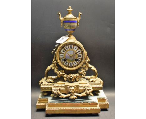 A French gilt metal mantel clock, the 8.5cm dial with Roman numerals, set in a drum supported by leafy scrolls, surmounted by