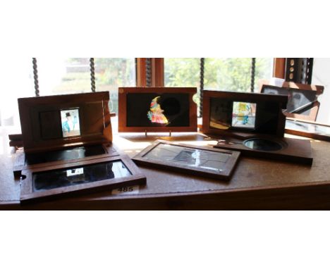 Fourteen animated magic lantern slides in coloured glass with wooden frames, some named Milikin &amp; Lawley, some A/F