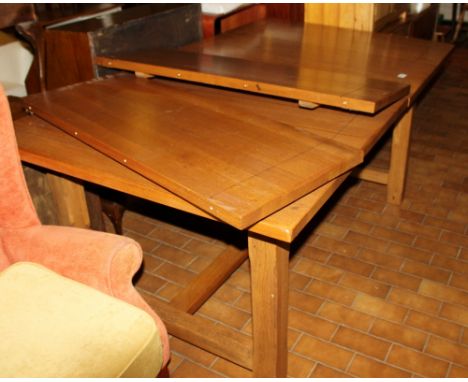 Large light oak extending dining table with stretcher and six matching dining chairs and two carvers