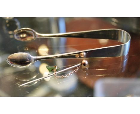 Pair of silver sugar tongs, hallmarked, London 1918 and a presumed gold headed stick pin