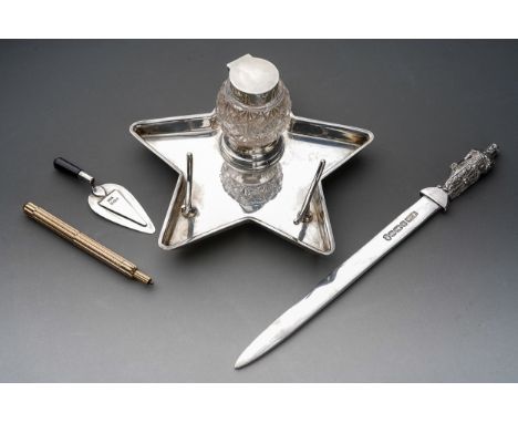 An Edwardian silver desk stand of five point star form, fitted with a central glass and silver mounted inkwell and pen rest, 