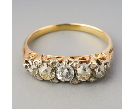 A yellow metal diamond five stone ring, set with graduating old European cut diamonds, diamond point spacers, approximate rin