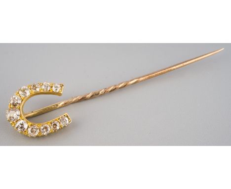 A late Victorian diamond set tie pin of horseshoe design, set with 11 old European cut diamonds, claw-set. Estimated total di