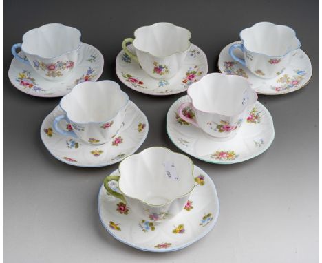 A set of six Shelley breakfast cups and saucers, pattern no 13240, decorated with flowers, harlequin coloured handles, green 