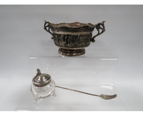 A HALLMARKED SILVER TOPPED GLASS MUSTARD POT ALONG WITH AN EASTERN WHITE METAL TWIN HANDLED BOWL AND PICKLE FORK MADE FROM IN