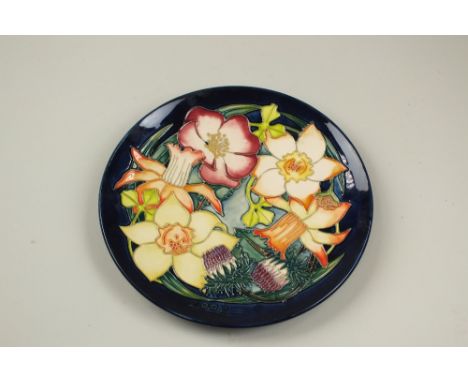 A Moorcroft plate commemorating the Golden Jubilee, 2002, decorated with yellow lilies, a limited edition numbered 1/750, 22.